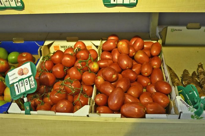 Cajas de tomates: tomates en rama y tomates de pera en un mercado de Madrid.
