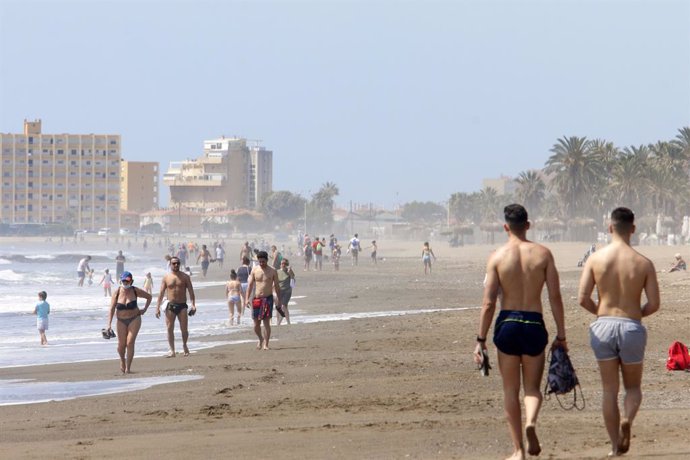 Paseantes disfrutan de la playa de Huelín durante la Fase 1 