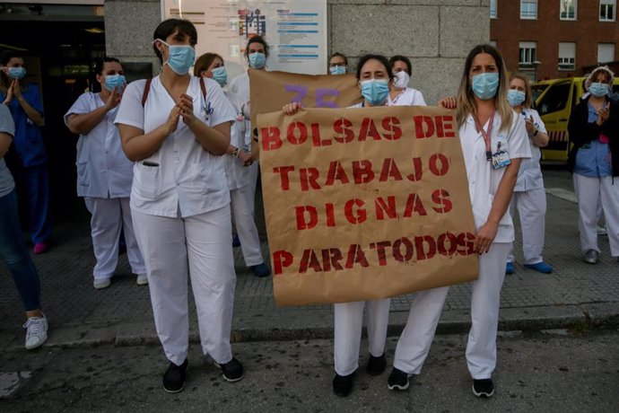 Personal sanitario del Hospital Clínico San Carlos de la Comunidad de Madrid sostienen un cartel en el que se lee 'Bolsas de trabajo dignas para todos'.