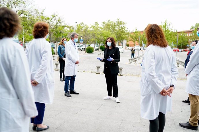 La presidenta de la Comunidad de Madrid, Isabel Díaz Ayuso (centro), habla con varios profesionales sanitarios tras guardar un minuto de silencio en la puerta del Hospital Universitario Fundación Alcorcón, en Alcorcón/Madrid (España) a 4 de mayo de 2020.
