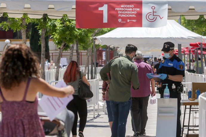 Vecinos del municipio madrileño de Torrejón entregan su identificación para realizarse una de las pruebas diagnósticas de Covid-19