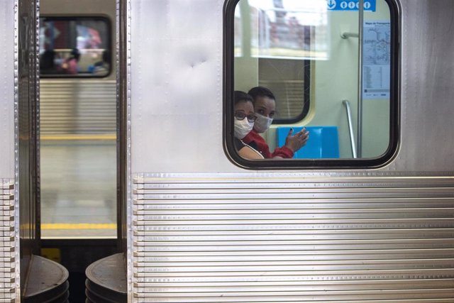 Dos personas con mascarilla en el tren por el coronavirus en Sao Paulo. 