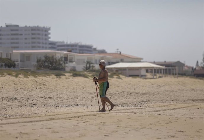 Una persona en la playa de Punta Umbría, abierta para el paseo y la práctica deportiva como único uso permitido, durante la segunda semana de la Fase 1. En Punta Umbría (Huelva, Andalucía, España), a 21 de mayo de 2020.
