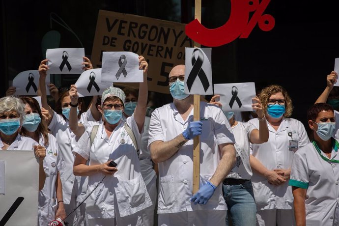 Treballadors sanitaris protegits amb mascarilla es reuneixen a les portes de l'Hospital Clínic de Barcelona amb pancartes i crespons negres per reivindicar contractes dignes i més personal, així com recordar als morts per la crisi del Covid-19. 