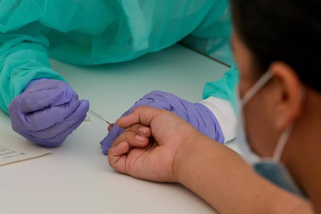 Una trabajadora sanitaria totalmente protegida realiza una prueba diagnóstica del coronavirus en una imagen de archivo.