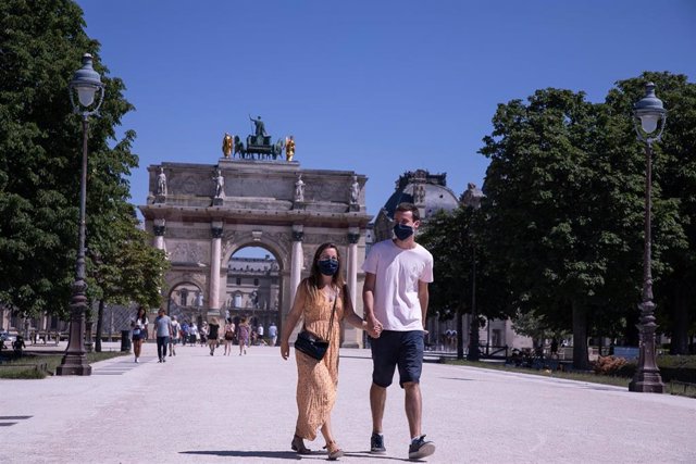 Gente paseando con mascarilla por el Parque de las Tullerías de París, Francia