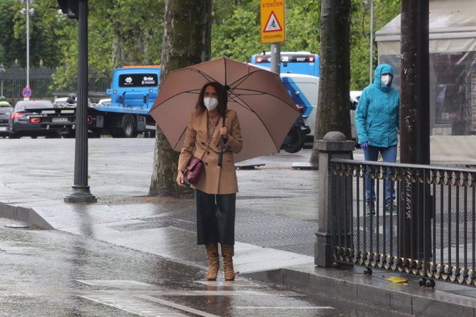 Una mujer con paraguas en Madrid este 14 de mayo, día en que hubo lluvias y bajada de temperaturas en toda España