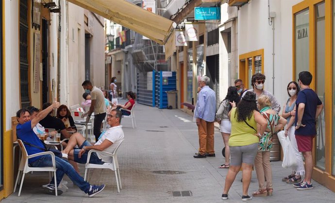 En un bar céntrico de Sevilla, los clientes ocupan todas las mesas de la terraza  y otros esperan una cola para poder consumir en el inicio de la Fase 2