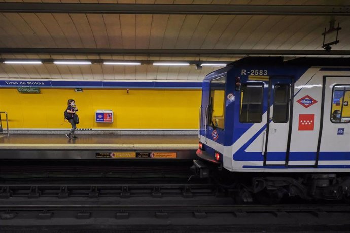 Una pasajera se dispone a entrar en un tren que accede a una estación de Metro de Madrid.