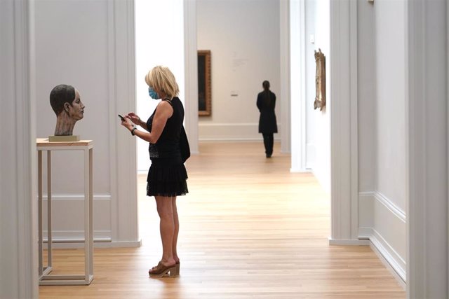 Una visitante protegida con mascarilla le hace una foto con su teléfono móvil a una escultura el día en el que el Museo de Bellas Artes de Bilbao reabre sus instalaciones después de la etapa de cierre por el coronavirus