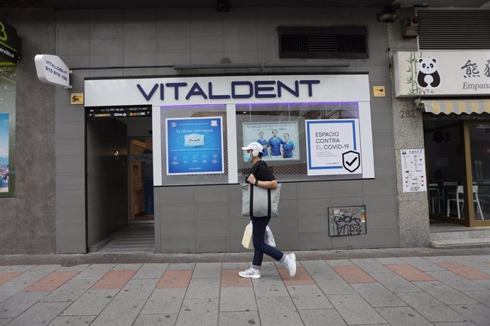 Un hombre con mascarilla pasa junto a la entrada de una clínica Vitaldent el día en el que la empresa ha reabierto su red de clínicas en todo el territorio nacional, entre ellas las 47 de la región madrileña, tras implementar un protocolo post Covid-19 