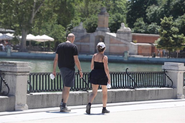 Dos personas pasean por el Parque de El Retiro durante el cuarto día de la Fase 1 en Madrid, que supuso la apertura de los grandes parques de Madrid, que permanecían cerrados para evitar aglomeraciones, y que se suman a los recintos de distrito con menos 