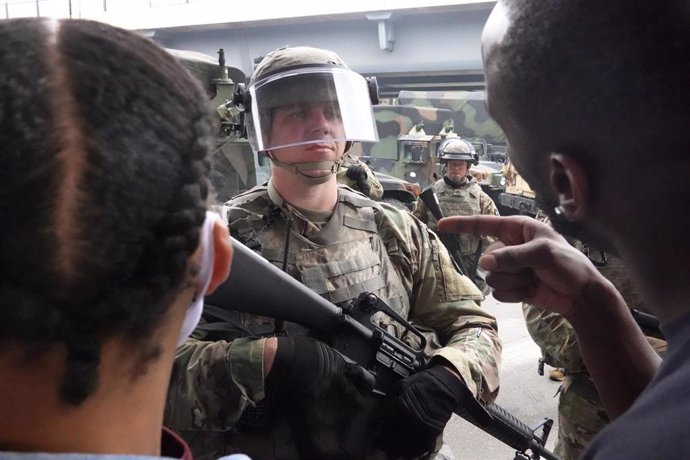 Manifestantes negros protestando frente a un militar de la Guardia Nacional