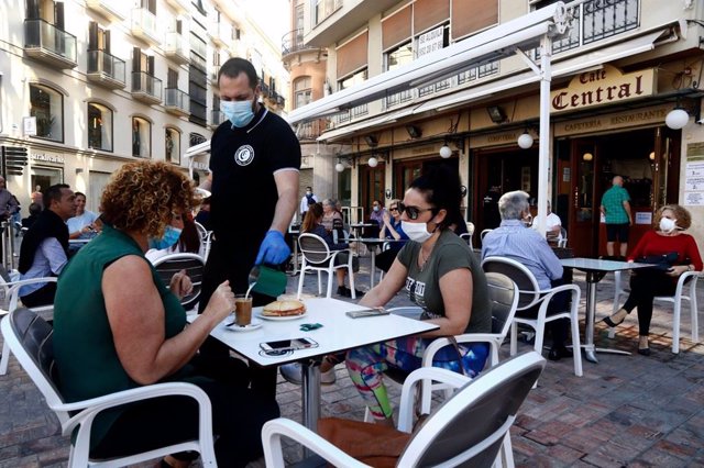 Un camarero atiende en una terraza el primer día en fase 1 de Málaga