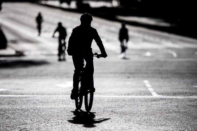Varias personas realizan deporte en bicicleta por las calles de Madrid 