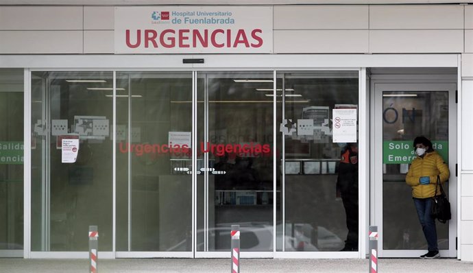 Una mujer protegida con guantes y mascarilla en la entrada de Urgencias del Hospital de Fuenlabrada.