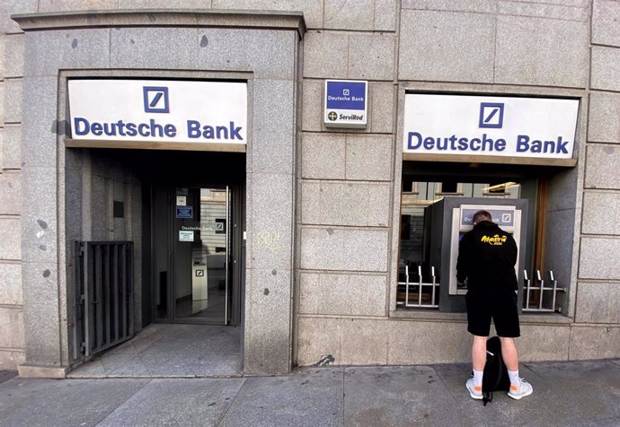 Un hombre retira dinero de un cajero Deutsche Bank, en Madrid (España), a 7 de febrero de 2020.
