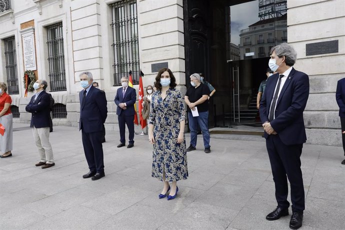 La presidenta de la Comunidad de Madrid, Isabel Díaz Ayuso (2d), guarda un minuto de silencio en memoria por los fallecidos por el COVID-19 en la Puerta de Sol junto a representantes del sector sanitario.
