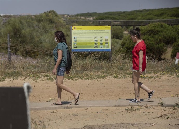 Dos personas caminan hacia la playa de Punta Umbría, abierta para el paseo y la práctica deportiva como único uso permitido, durante la segunda semana de la Fase 1. En Punta Umbría (Huelva, Andalucía, España), a 21 de mayo de 2020.