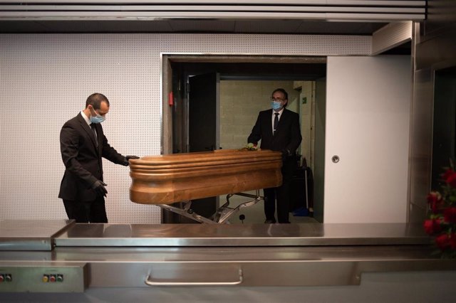 Operarios del Crematorio de Girona trasladan un ataúd, ya desinfectado, de una víctima con Covid-19 para introducirlo en el horno, el 6 de mayo de 2020.