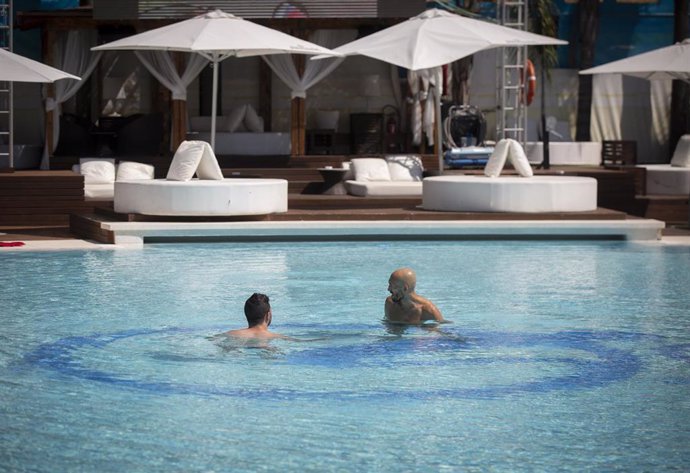 Dos personas se bañan en la piscina recreativa del Club Ocean, abierto al público durante la Fase 2, en Sevilla