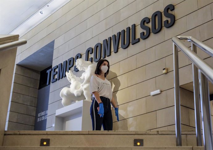 Una dona protegida amb guants i mascarilla a l'entrada d'una exposició en el Museu Institut Valenci d'Art Modern (IVAM) 