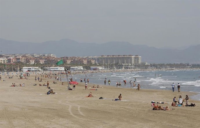 Bañistas en la Playa de la Malvarrosa, con bandera verde durante el primer día de la Fase 2, cuando se puede acceder a las playas de la misma provincia, isla o unidad territorial de referencia establecida en el plan de desescalada