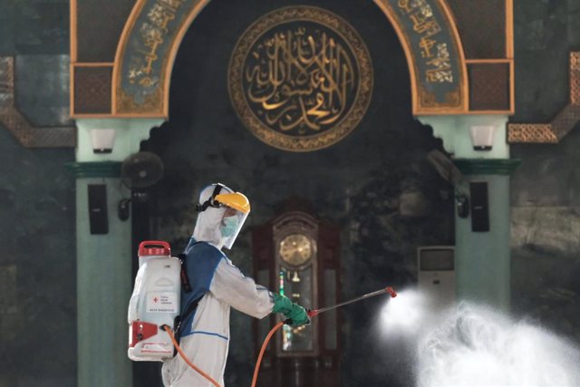 Un trabajador desinfecta una mezquita en Indonesia. 