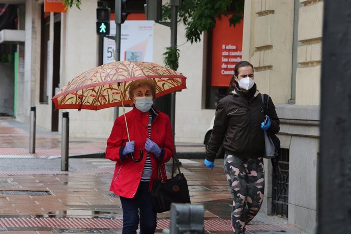 Dos mujeres pasean en la capital en un día de lluvia 