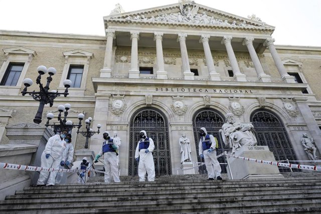 Agentes de la UME con mochilas nebulizadoras en la desinfección de las escaleras de la entrada de la Biblioteca Nacional