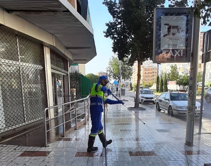Un operario de Limasa desinfecta y limpia una calle cercana a un centro sanitario de Málaga