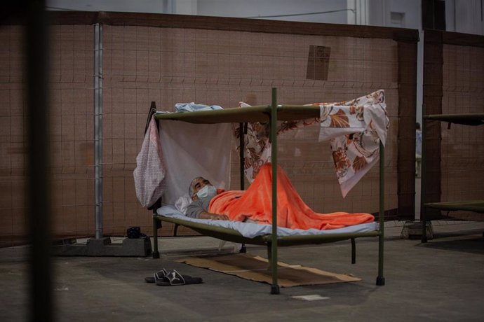Un hombre descansa en su cama en el interior de las instalaciones del albergue de Fira Barcelona, habilitado por la crisis de la pandemia del coronavirus para 225 personas sin techo. En Barcelona, Catalunya (España), a 28 de mayo de 2020.