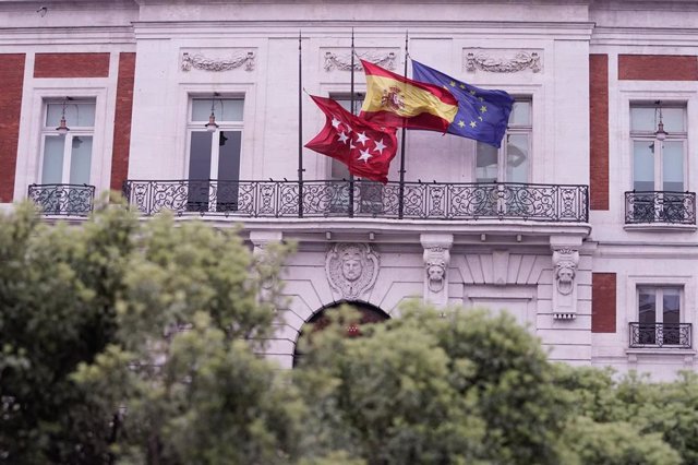 Las banderas ondean a media asta en la sede de la Comunidad de Madrid en la Puerta del Sol