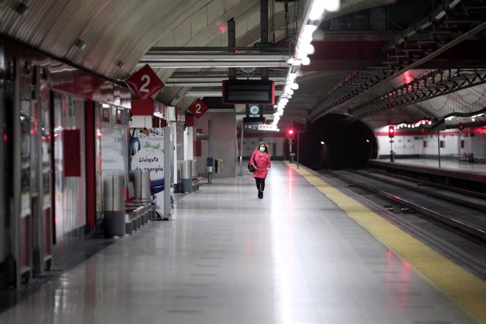 Una mujer con mascarilla en un andén de la estación de cercanías de Nuevos Ministerio de Madrid