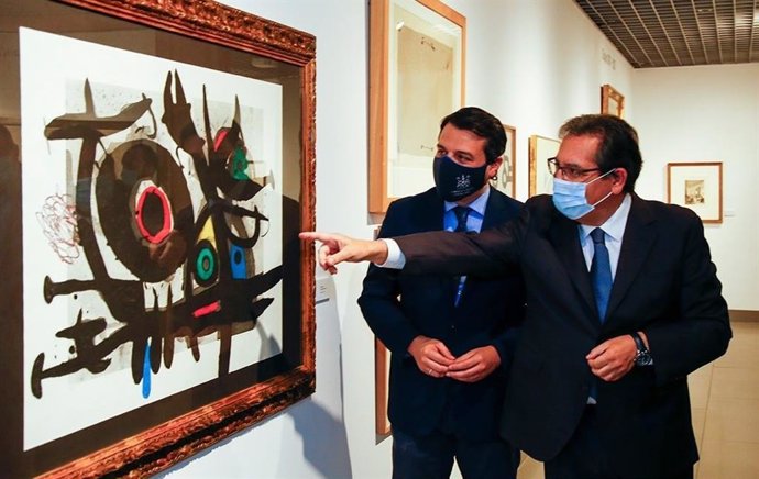 Antonio Pulido señala una de las obras expuestas, junto a José María Bellido.