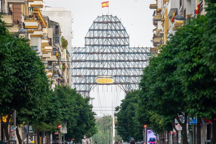 La calle Asunción de Sevilla con la portada de la feria al fondo en fase de desmontaje donde hubiera estado atestada de gente camino de la Feria de Abril suspendida por el estado de alarma del coronavirus Covid-19. 