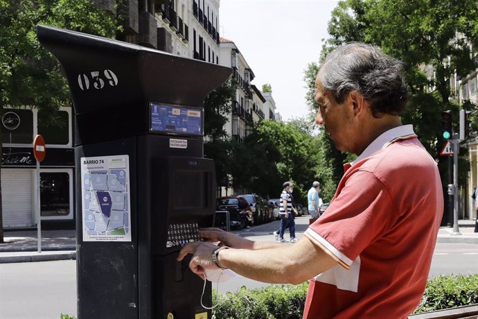 Un hombre utiliza el parquímetro del Servicio de Estacionamiento Regulado (SER) de Madrid 