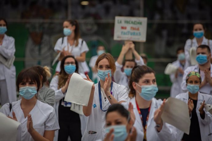 Personal sanitari protegits amb mascarilla sostenen cartells durant la concentració de sanitaris en el Dia Internacional de la Infermeria (Arxiu)