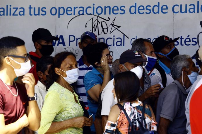 Colas para entrar en un banco de la ciudad venezolana de Valencia durante la pandemia de coronavirus