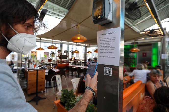 Una persona consulta la carta de productos con código QR en un bar de el Mercado de Colón durante la fase 2 de la desescalada en la pandemia de coronavirus COVID19. En Valencia, España, a 3 de junio de 2020.