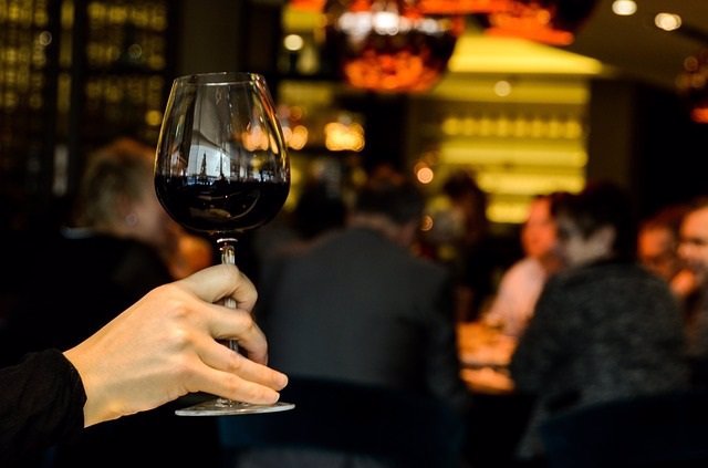 Una mujer sostiene una copa de vino en un bar de ocio nocturno.