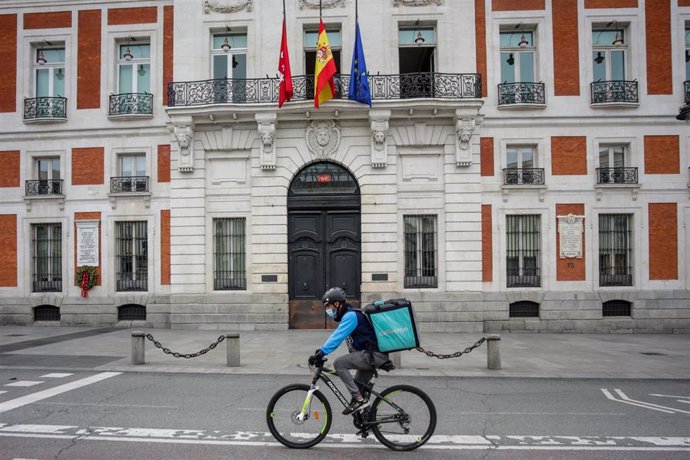 Un 'rider' de Deliveroo circula por la Puerta del Sol, en Madrid (España).