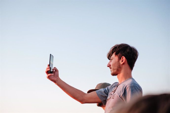 Joven haciéndose un selfi con su móvil.