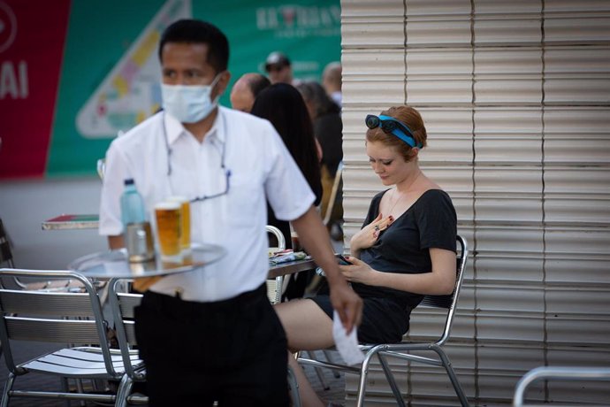Un camarero sirve en la terraza de un bar durante el segundo día de la reapertura al público de las terrazas al aire libre, durante el segundo día de la Fase 1 en Barcelona, Catalunya (España) a 26 de mayo de 2020.