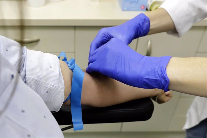Un trabajador sanitario prepara a una paciente para la extracción de sangre para realizar el test serológico IgM/IgG SARS-CoV-2