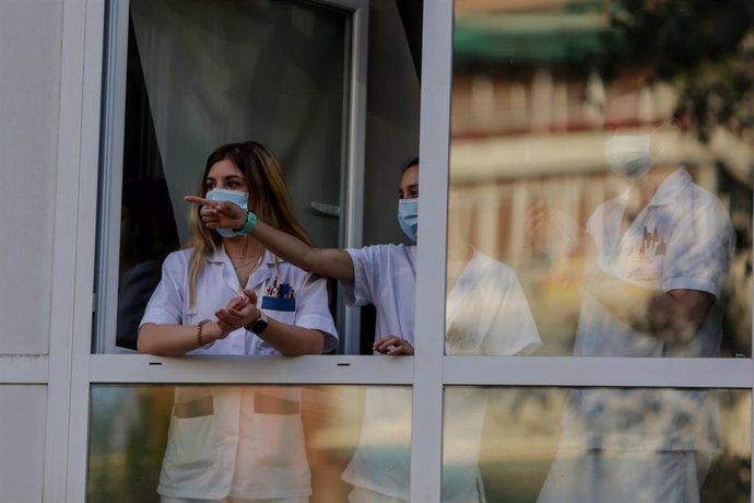 Sanitarios aplauden desde una ventana de del Hospital Fundación Jiménez Díaz cuando en la Fase 1 de la desescalada continúan los aplausos en homenaje a los profesionales sanitarios y demás sectores que han sido esenciales durante la pandemia 