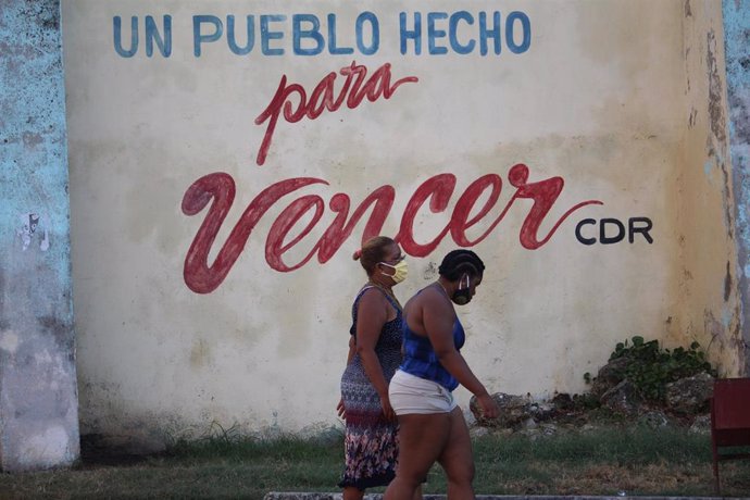 Dos mujeres pasean con mascarilla por una calle de La Habana durante la pandemia de coronavirus