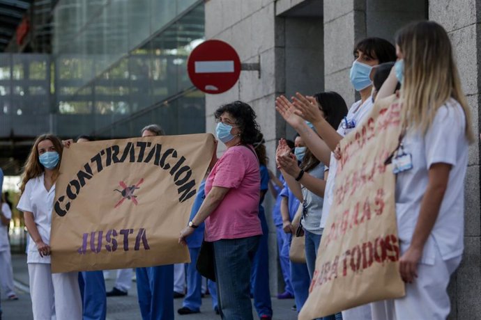 Personal sanitario del Hospital Clínico San Carlos de la Comunidad de Madrid sostienen carteles en los que se lee 'Contratación justa'.
