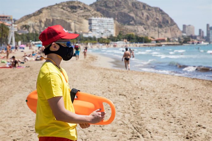 Un socorrista protegido con mascarilla vigila la Playa del Postiguet. En Alicante, Comunitat Valenciana (España), a 1 de junio de 2020.