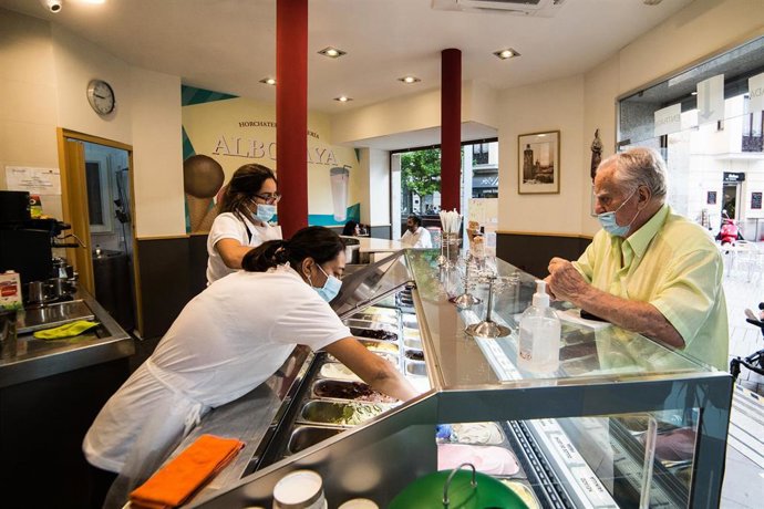 Clientes en la heladería Alboraya el día en el que se reabren al público los establecimientos de hostelería y restauración
